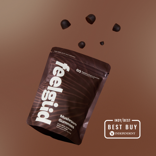 Feelgood mushroom gummies package with scattered gummies on a brown background